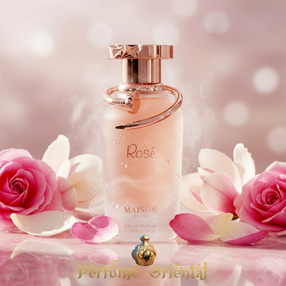 Botella MAISON ASRAR ROSÉ Eau de Parfum 110ml rodeada de pétalos de rosa